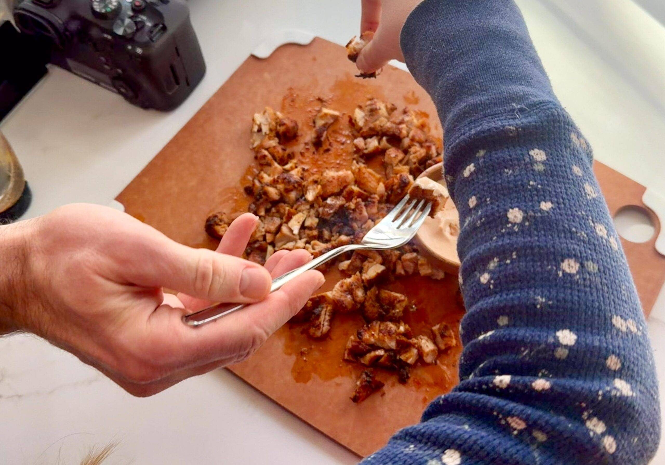 Family eating air fryer chicken thighs on cutting board