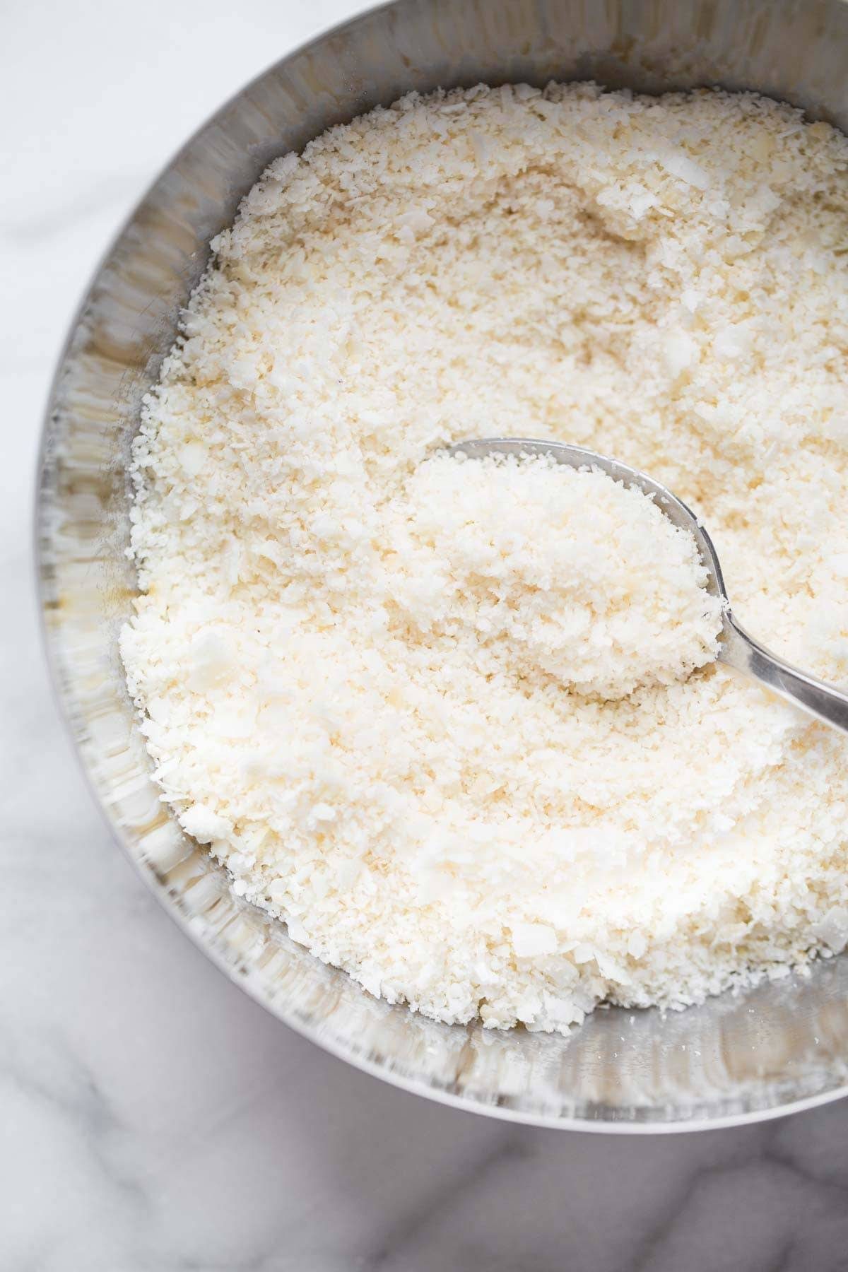 Coconut shreds in a bowl with a spoon.