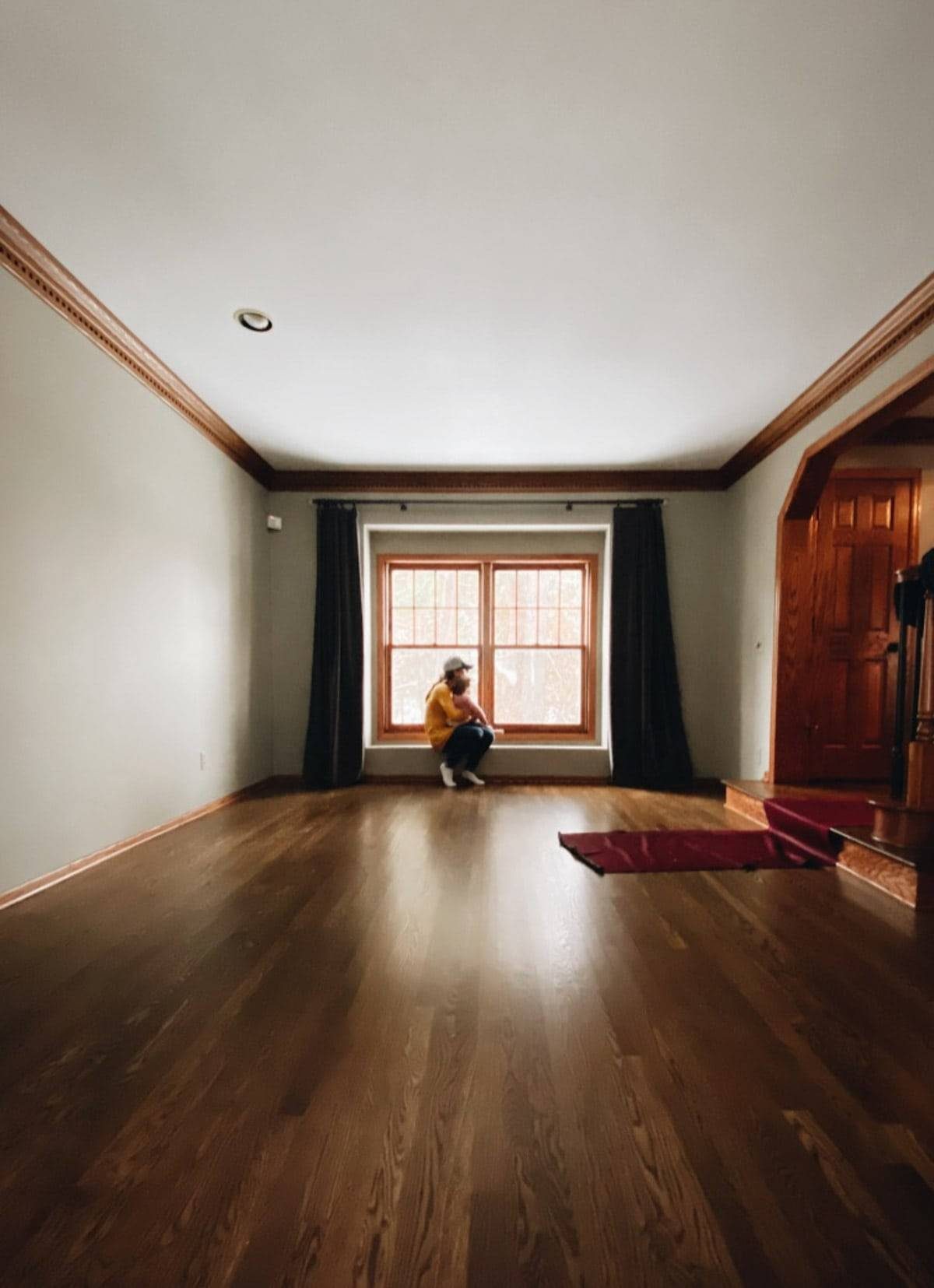 A person sitting on the far end of an empty room.