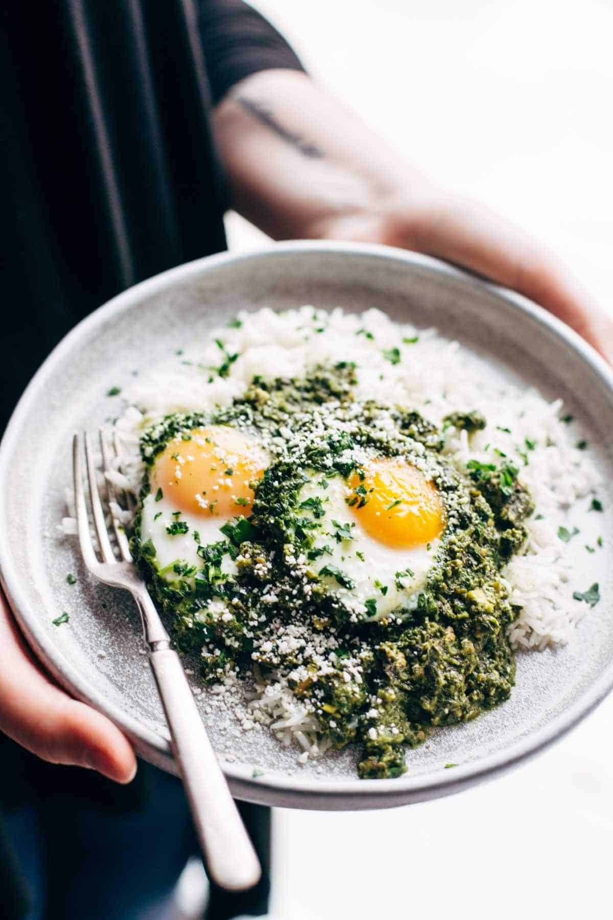 plate with eggs and creamy green shakshuka with a fork