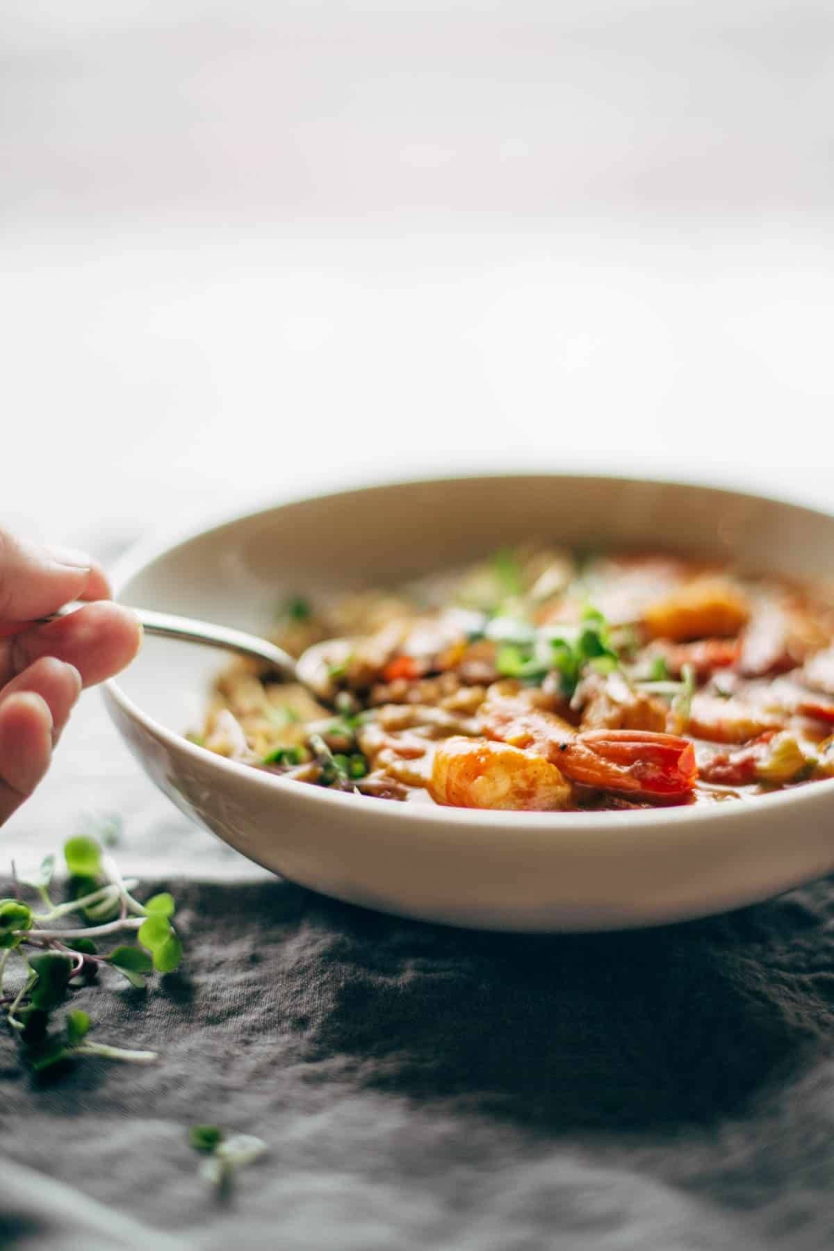 Gumbo shrimp in a bowl with a spoon.
