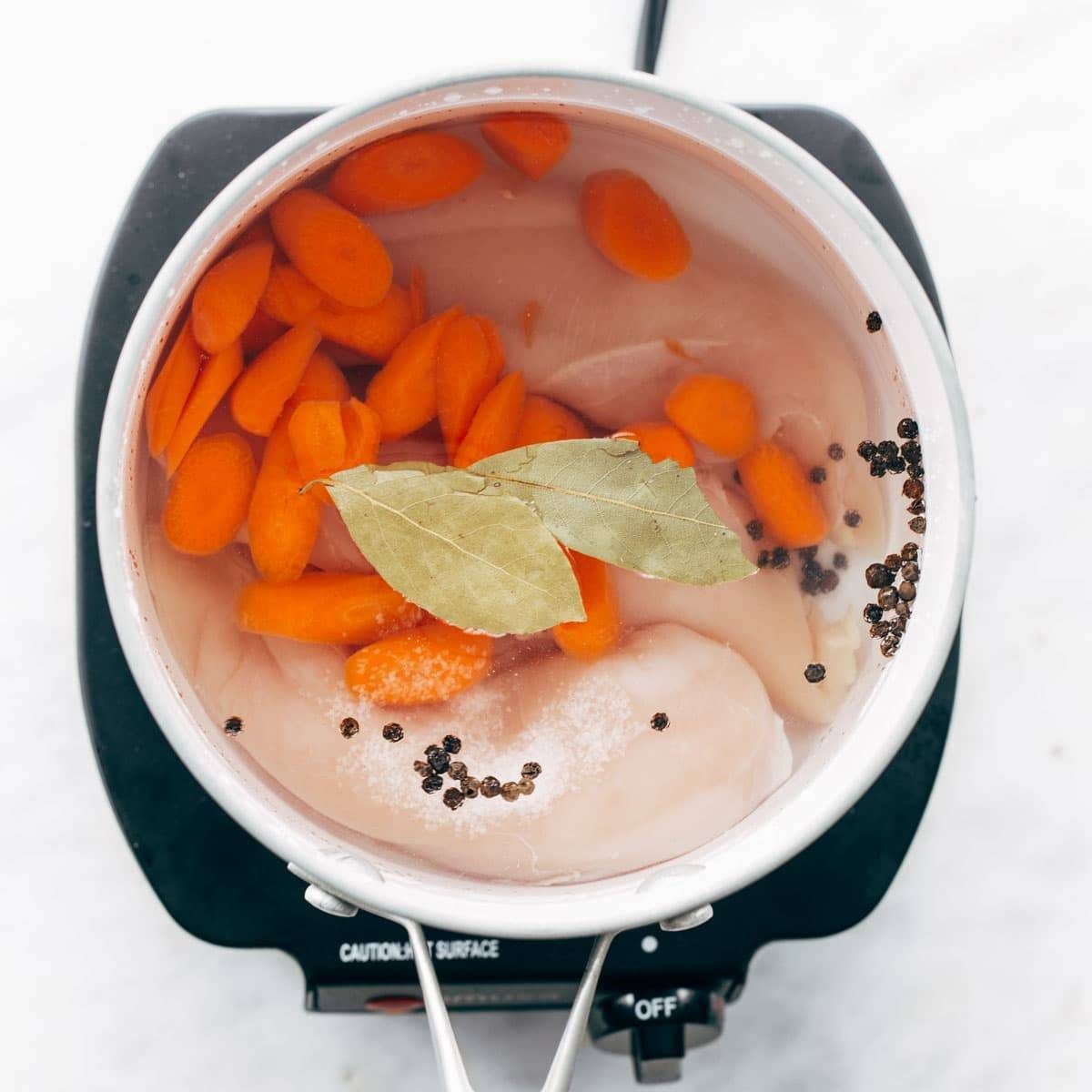 Adding aromatics to chicken breasts.