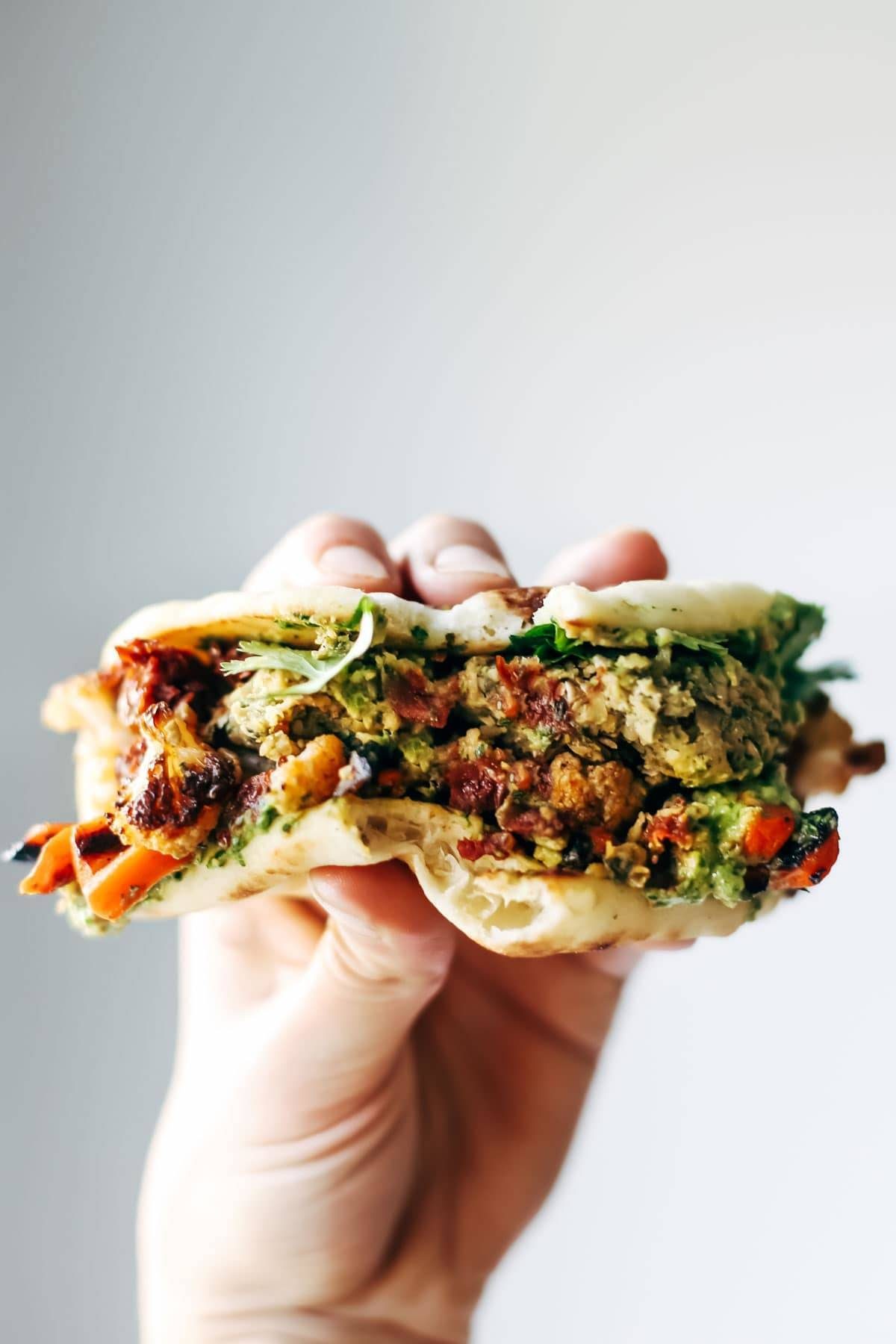 Naan-wich: 5 ingredient falafel, roasted veggies, and avocado sauce stuffed between pillowy garlic naan. Best sandwich recipe I've ever made. | pinchofyum.com