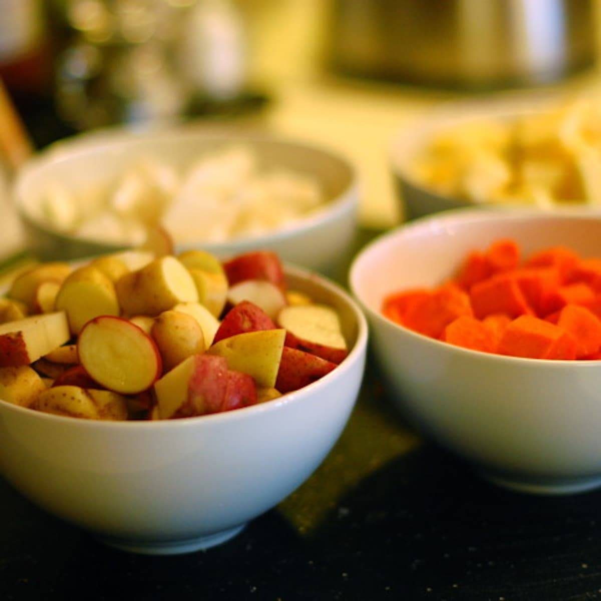 Root vegetable stew ingredients in bowls.