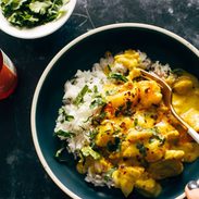 Yellow chicken curry in a bowl with a fork